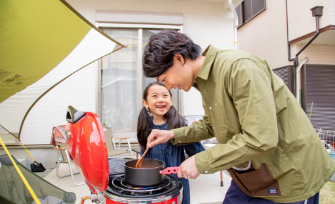 料理をする父と笑顔で話しかける娘